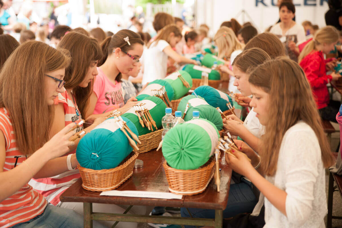 Otroci pletejo čipko na Festivalu idrijske čipke